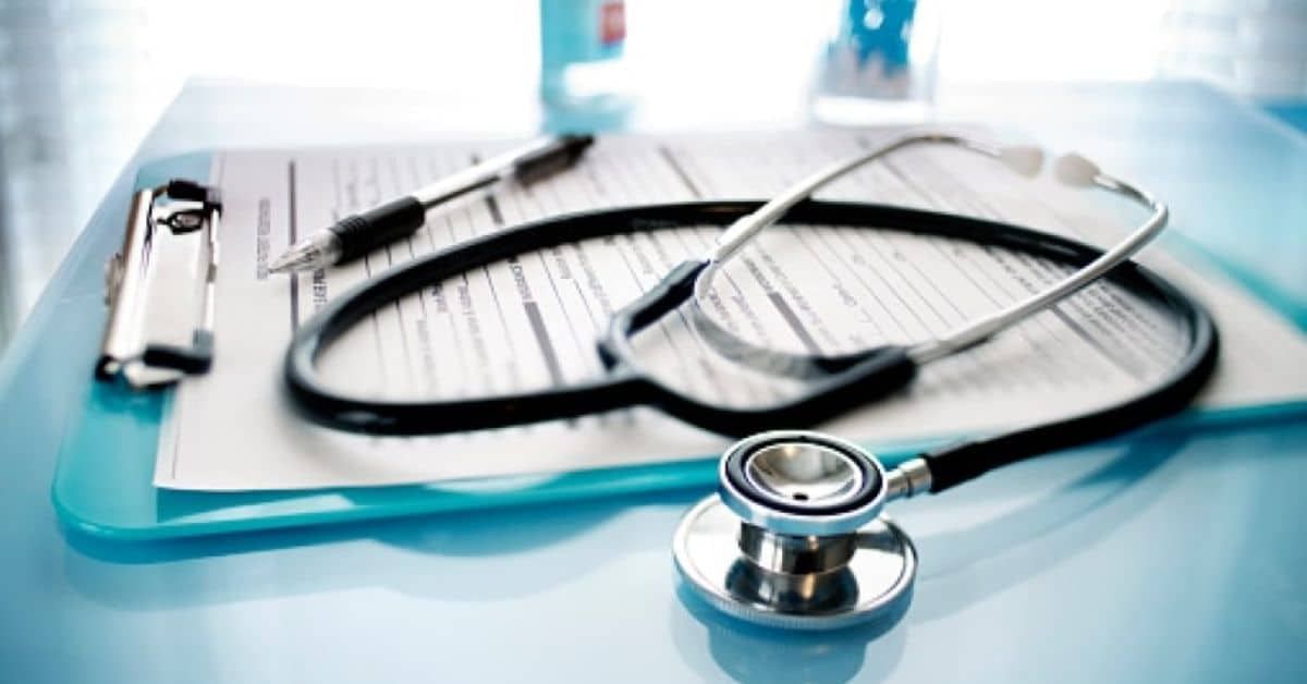 A stethoscope and pen on a clipboard