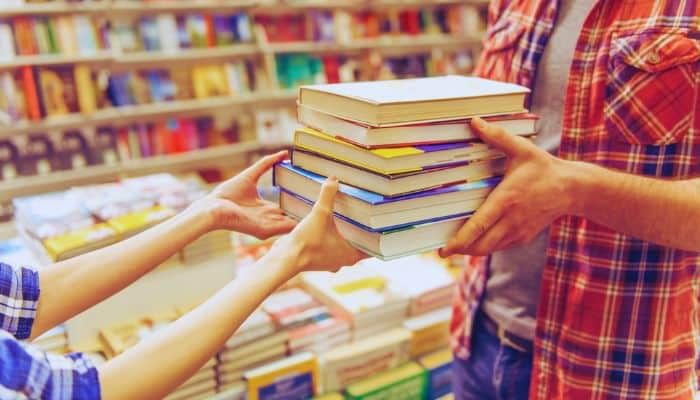 A person holding a stack of books