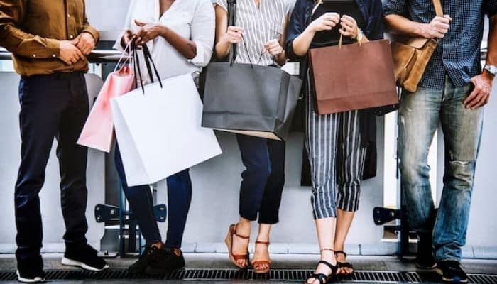 A group of male and females holding shopping bags